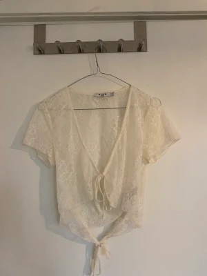 Spetstopp med knyting - Söt topp med två knytningar framtill. Helt oanvänd.