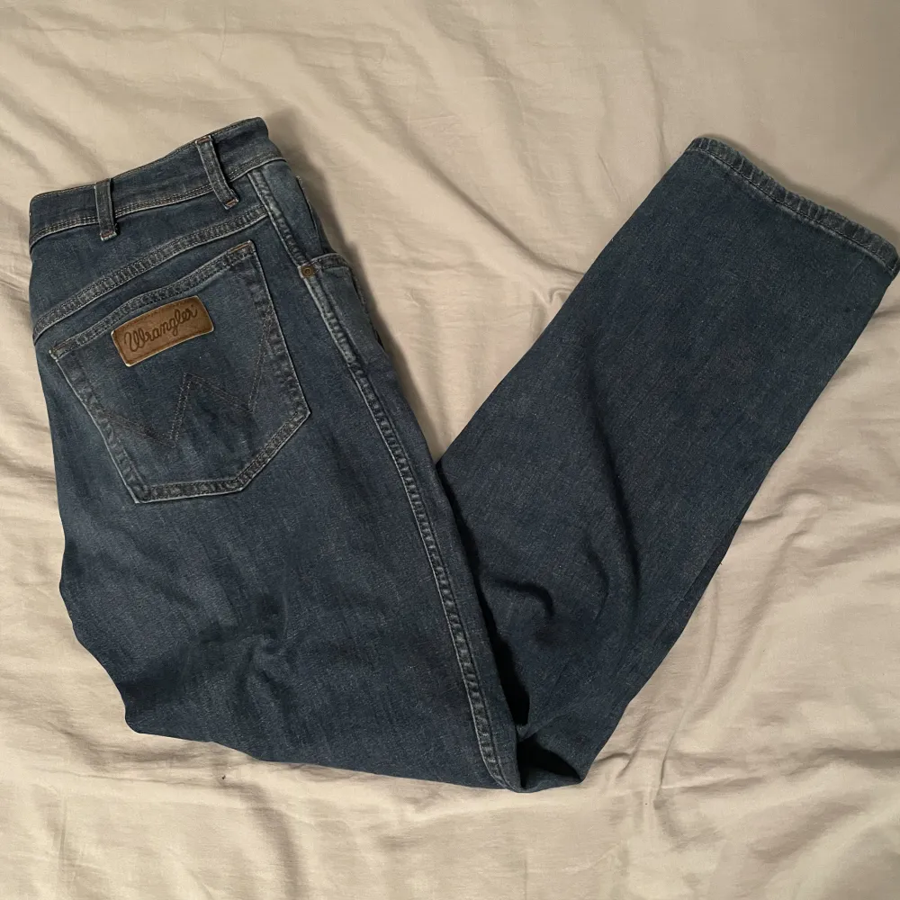 Mörkblåa jeans från Wrangler | Storlek: 31/30 - Skicket är väldigt bra, endast använda ett få tal gånger - Vårat pris: 349 - Nypris: 699 - Modellen är 180. Jeans & Byxor.