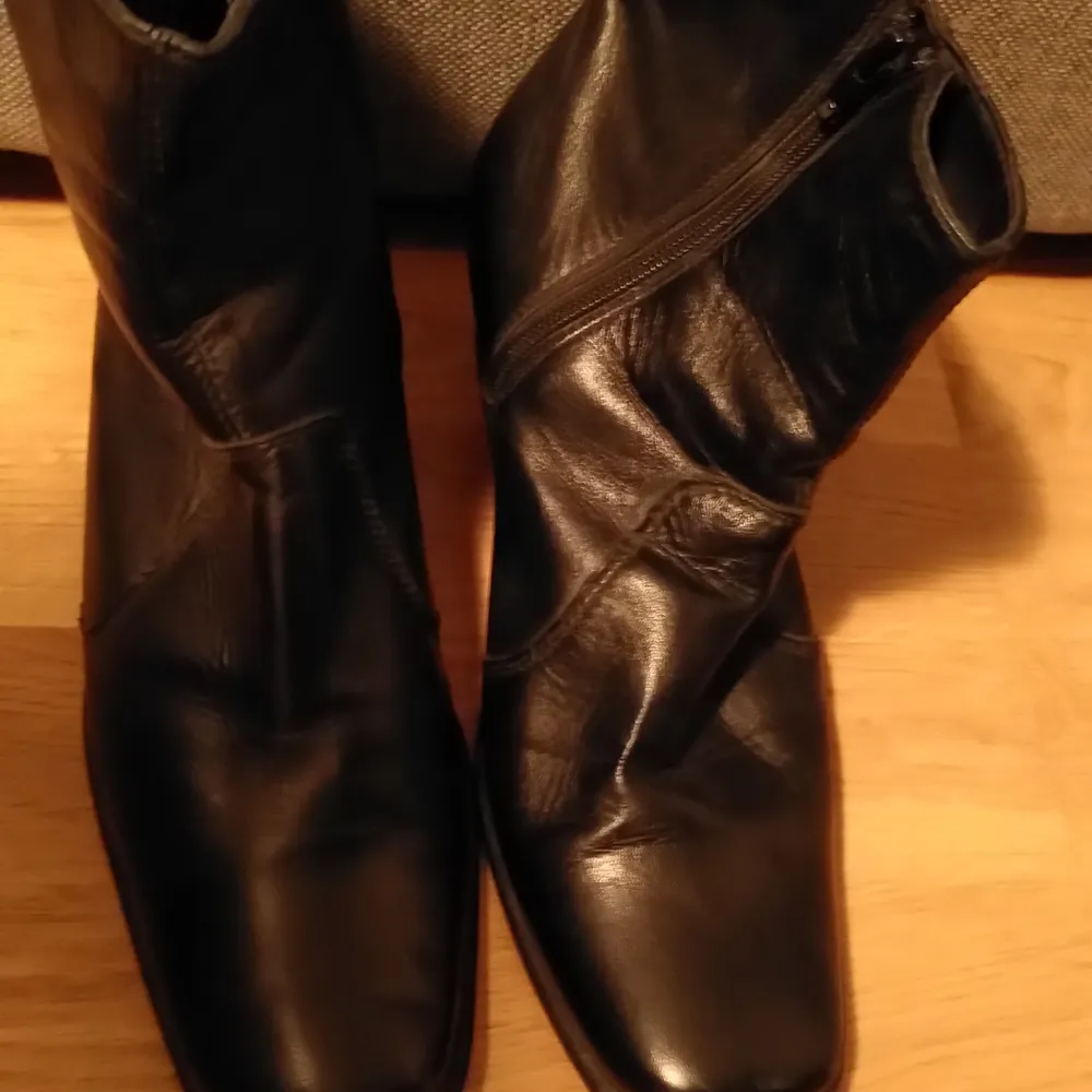 Svarta boots helt foder på insida, läder liknande material. Kan inte säga exakt. Skor.