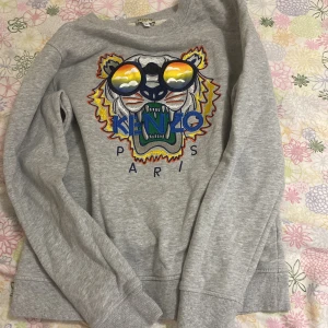 Kenzo hoddie - Kenzo hoddie helt oanvänd då är den i helt ny skick, används ej för den va liten. Säljs för 450kr priset kan gå ner,kids storlek 14A står det.