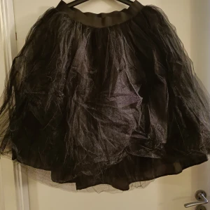 Svart tyllkjol  - Tre lager tyll över innerkjol. Ca 60cm lång, resår i midjan. Aldrig använd.