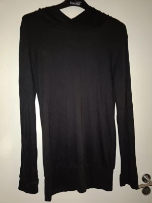 Svart tröja  - Svart tröja med luva, mudd nertill. Ganska tunt material, typ lite tjockare än som hos en vanlig t-shirt. Aldrig använd.