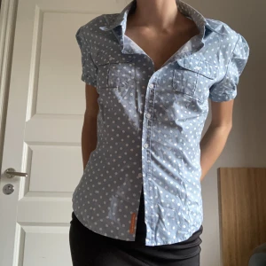 Blus - Jättefin ljusblå skjortblus med vita prickar och knappar längst fram så man kan knäppa upp precis hur man vill. Nyttskick🤍🩵