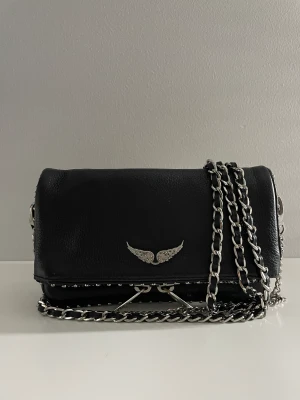 Svart Zadig väska - Zadig & Voltaire väska i modellen rock nano. Köptes för 2400 kr. Nästan helt oanvänd! Skriv för fler bilder eller frågor! Kan mötas upp i Stockholm annars står köparen för frakten! 💗💗