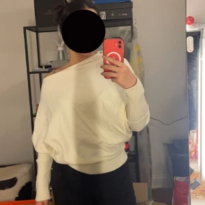 Stickad tröja  - Stickad beige-krämig tröja med sneddad Axel. Strl S/M