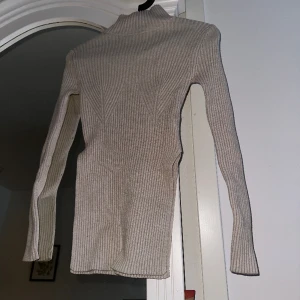 Stickad tröja - Beige stickad tröja från NAKD i storlek xxs, den är skuren på sidorna så den faller väldigt fin, stretchig🤍🤍 Köparen står för frakten, skickar via PostNord blå påse 🩵🩵