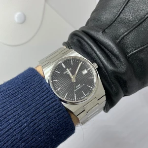 Tissot PRX Powermatic 80 - Tissot PRX Powermatic 80 40mm med svart urtavla. Den är köpt i år i januari och är sparsamt använd, därav i väldigt bra skick. Originalbox och länk tillkommer. Dessutom ett garantikort vilket innebär att klockan fortfarande har mer än 1 år kvar av garanti