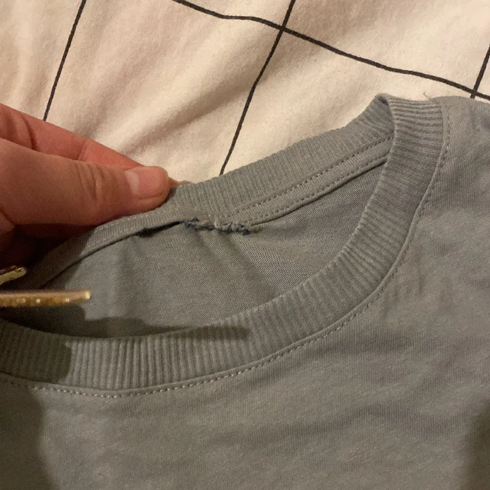 Nyskick, lappen är dock avklippt och då råkade tyget klippas upp men det är lagat och syns nästan inte alls på utsidan. . T-shirts.