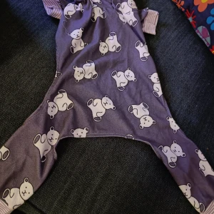 Söt hund overall  - Ryggmått ca 37cm, framben ca 13cm inkl. mudd, bakben ca 30cm inkl. mudd. Aldrig använd men har blivit tvättad. Vikbar krage.