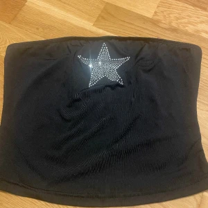 tubetop med rhinestones - svart tubetop med rhinestones format som en stjärna. använd endast en gång. bra material och i perfekt skick. inga defekter
