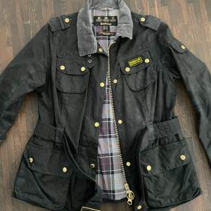 Svart Barbour jacka (vaxad) storlek 40, nyskick. Nypris 4000kr Passform: Classic/ Regular Yttermaterial: heavyweight 8oz barbour sylkoil vax, Foder: 100% bomull Barbour tartan.  Pris kan diskuteras vid snabb affär/upphämtning.