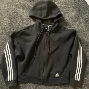 Adidas zip up hoodie - Köpt ny, använd fåtal gånger för några år sedan. Men säljer pga byta av stil. Smått solblekt, men inget som märks av. Annars i helt ny skick. Storlek s men lite oversize så passar för de som vanligtvis har M eller L