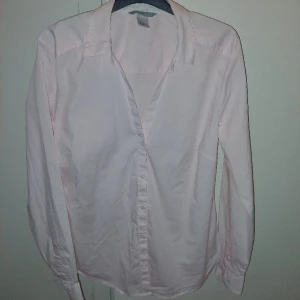 Figursydd skjorta  - En fin figursydd skjorta i rosa från hm. Strl 40
