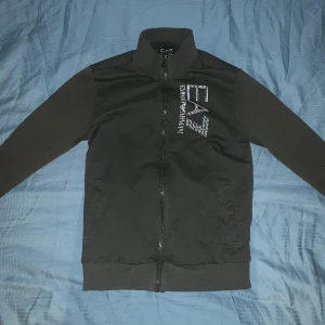 EA7 Emperior Armani - Zip tröja i bra skick i mörk grön färg, säljer för att den inte är till användning längre men är fortvarande riktigt snygg, storleken är XS men fungerar för S med.