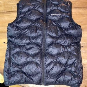 PeakPerformance väst - Svart lite glansig äkta Peak Performance helium väst i väldigt gott skick. Perfekt att ha under en tunnare jacka nu under vintern. Skriv ifall ni har några frågor eller vill ha mer bilder på den.