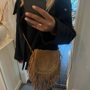 Väska med fransar - Brun axelremsväska med fransar.