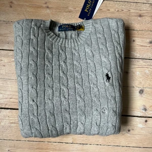 Kabelstickad Ralph Lauren tröja - Oanvänd kabelstickad Ralph Lauren tröja med lappar kvar! Storlek S och sitter perfekt. Köparen betalar frakt.
