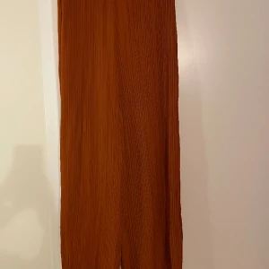 H&M-byxor - Kopparfärgade tunna byxor från H&M, storlek S. Använda men i mycket bra skick.