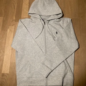 Ralph lauren zip  - As snygg Ralph Lauren zip. Tröjan sitter som en standard M. Tröjan är helt ny och är därför helt oanvänd. Fick tröjan i present men har redan en sådan och väljer därför att sälja. Passar as bra med mörkblå jeans. Skriv för fler bilder🤍