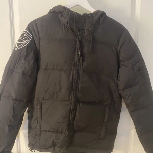Svart D.brand vinterjacka - Köpt får några år sedan och är använd, har små defekter med lite missfärgning på insidan som syns på bild 2 & 3, men annars i bra skick. Den är lite skrynklig på bilderna då den legat ner packad men den kommer räta ut sig. Skriv vid funderingar.
