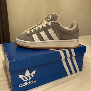 Adidas Campus 00s - Hej! Säljer nu ett par eftertraktade Adidas campus 00s i storlek 35,5.  Dem är helt oanvända och bara precis öppnade från lådan. Tyvärr var dem för små för mig därav att jag säljer dem.  Ett par gråa bekväma och skitsnygga sneakers helt enkelt!🫶🏽  