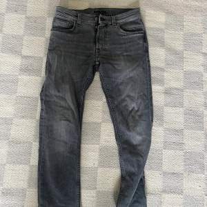 Gråa nudie jeans. Modellen heter Grim Tim och färgen är ”Pale Grey”. 