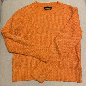 Stickad tröja  - Orangea stickad tröja med woolblend från Bikbok.  Använt skick så lite noppriga men går lätt att ta bort