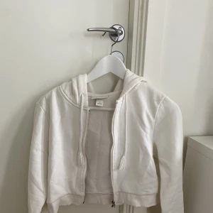 Vit ziphoodie - Snygg och skön croppad ziphoodie från Monki. 