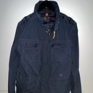 Parajumper windbreaker - Säljer en sällsynt och riktigt stilig Parajumper windbreaker. Finns ett lagat hål emellan fickorna på vänstersida av jackan. Pga detta sänker jag såklart priset ytterligare. Annars är den i fint skick. Passar även M Pris kan alltid diskuteras:)