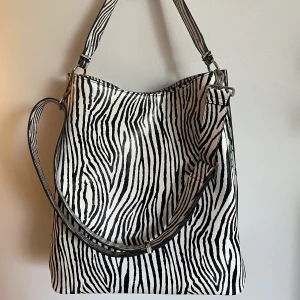 Zebraväska från Beck Söndergaard - ”Zebra Kayna Bag” från Beck Söndergaard. Nyskick/oanvänd, säljs pga använder ej. Stor väska, rymmer mycket. (Ord pris ca 999kr.)
