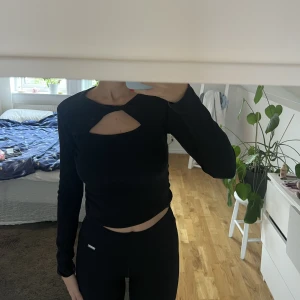 Svart topp - Svart topp med hål högst upp. 