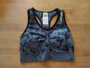 Gymshark camo sport bh, svart/grå - Sport bh från märket gymshark i nyskick. Endast testad. Med scrunch både fram och bak.