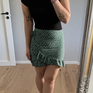 Kjol - Omlott-kjol. I ryggen sitter en dragkedja.