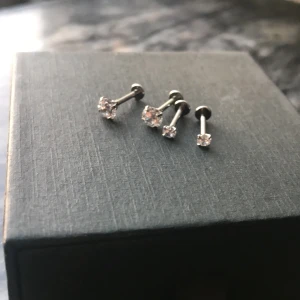 Nya diamant örhängen i rostfritt stål - Helt nya, aldrig använda då mina hål är för små. Så kanske inte för de som har hål tagna med piercingpistol. Gjorda i rostfritt stål och man skruvar i de i fronten så man tar av ”diamanten”. Självaste ”diamantens” diameter på de stora ca: 5mm Små ca: 3mm