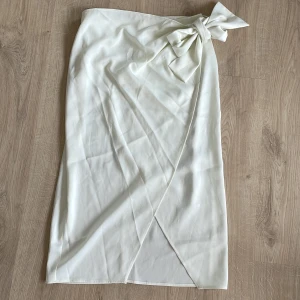 Vit omlottkjol - Aldrig använd. Passar jättebra till fest. Den går ner till knäna typ