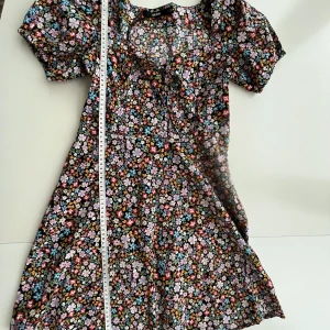 Blommig klänning med snörning - Blommig klänning från Bikbok Snörning fram Storlek 36 Använd fåtal gånger  Finns i Torslanda eller kan mötas upp på Lindholmen (Göteborg)