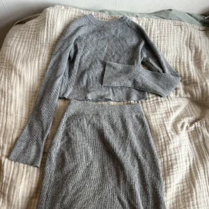 Stickat  - Ett stickat twopiece sätt. Tröjan är lång i ärmen, tajt och en aning croppad. Kjolen är lite längre, tajt och har en slits.