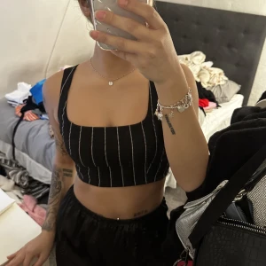 Topp - En svart randig topp i storlek 32 passar även 34. 