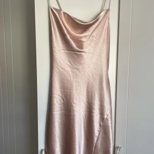 Klänning från nelly - Använd i 2h så intoppen skick! Köpt för 1200kr säljer för 600kr. Den är i färgen champagnerosa. Storlek 36 men passar även om du är mellan 36/38