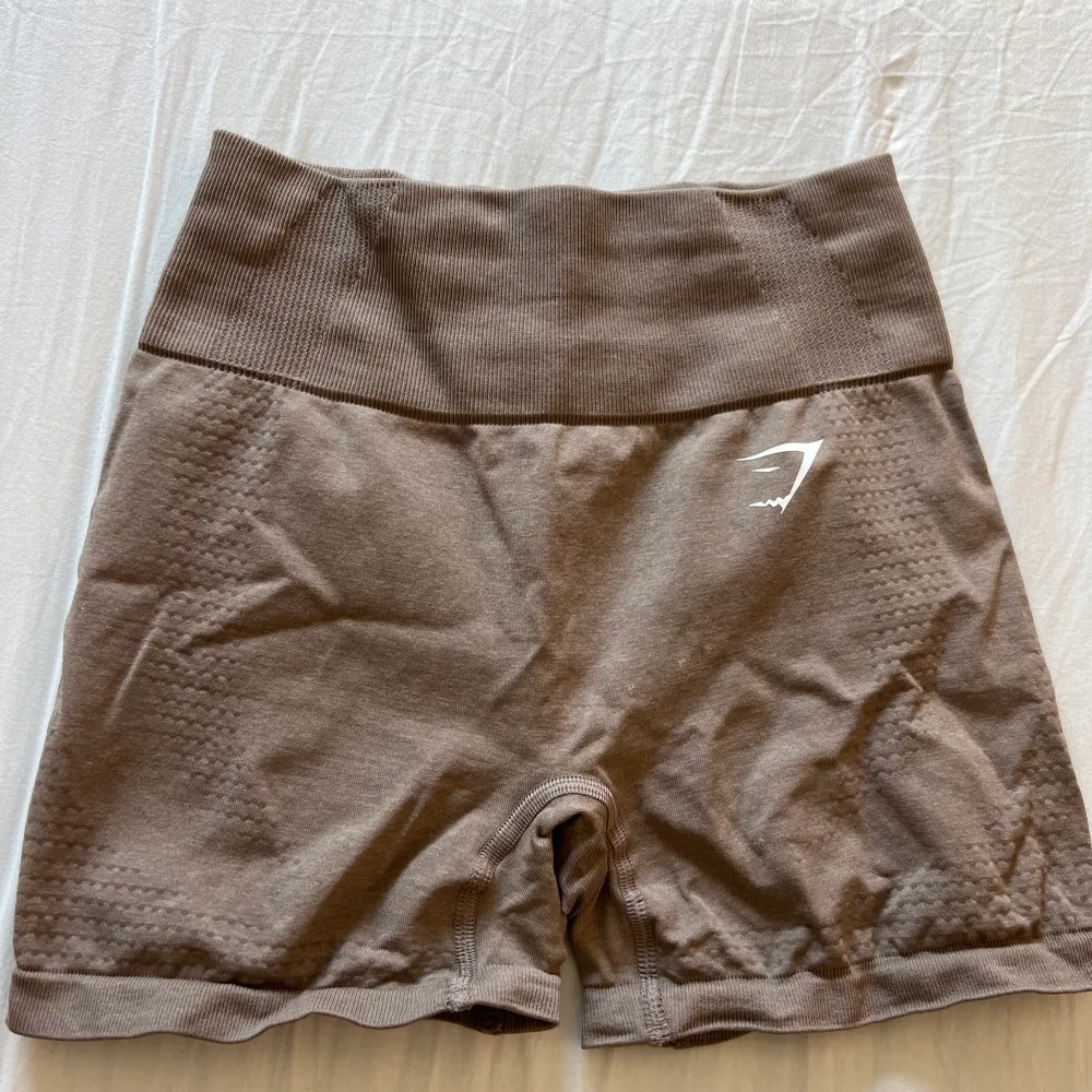 Bruna gymshark shorts storlek S, knappt använda och endast skrynkliga pågrund av att de legat länge i garderoben utan användning, kan tvättas och strykas innan postning så blir dom som nya💕. Shorts.