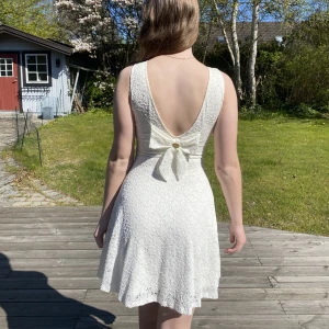 Klänning - Krämvit Chiara Forthi klänning med blommönster i tyget, inbyggda vadderade kupor, söt rygg med rosett, strechigt tyg, perfekt till midsommar, skolavslutning, student eller konfirmation, storlek xs men passar mig som har S i det mesta, använd 1-2 gånger