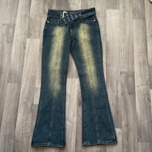 Lågmidjade jeans - Aldrig använd!! Helt ny och lappen är på! Utsvängda jeans med skärp och lågmidjade. Säljer pga fel storlek, hade annars behållt ;)  