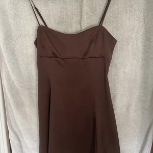 Klänning - Brun klänning ifrån Ginatricot. Använd 2 ggr. Bra skick. Storlek S. 