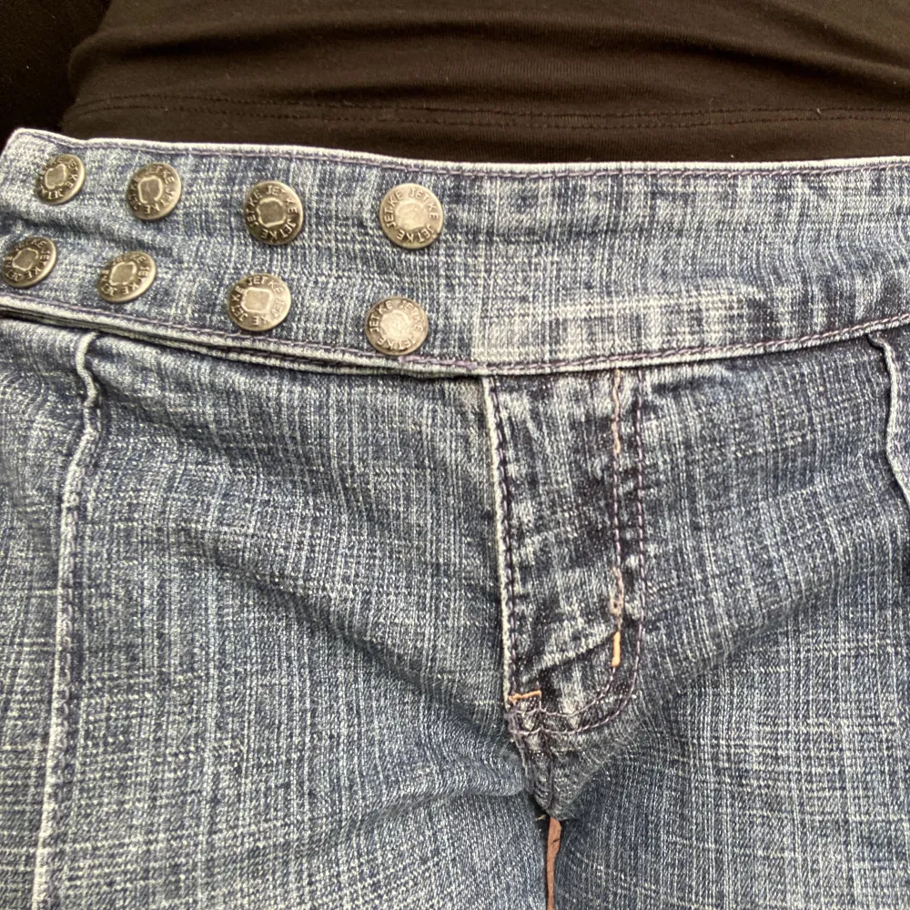 Lågmidjade utsvängda jeans med snygga knappar som man kan knäppa upp. Jag är ca 163cm lång och brukar ha storlek 28/36/S. Jeans & Byxor.
