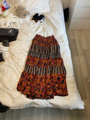 Kjol  - En lång kjol som går ner till mitt på vaderna på mig (168cm lång) köpte den på Beyond Retro. Har bara använts ett fåtal gånger av mig. Själv är jag M/L och den passar mig bra, extremt stretchiga runt midjan 