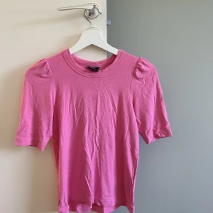 Rosa topp - Så så fin rosa t-shirt med lite puffärm. Köpte förra året i maj och använd max 3 gånger. Köpte för 400 från Lindex. Storlek Xs men jag har oftast S, och den sitter bra på mig. Jag säljer pga jag inte använder den.
