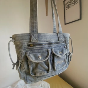 Denimväska - Handväska i denim aldrig använd perfekt skick. Rymmer mycke o skön att bära. 35x27 handtag är 27cm