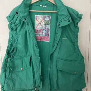 Vintage skidväst  - 80-tals väst från Prototype. Justerbara ärmar och underkant. Två stora fickor. Köpt secondhand men i bra skick. Storlek står ej men gissar på storlek L herr. Turkos i färgen men lutar mer åt det gröna hållet.