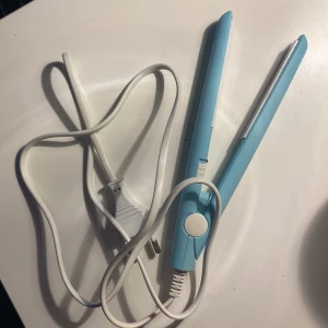 Platttång - Ett litet palttång som är blå värmer bra om man vill platta sitt lug eller hår.