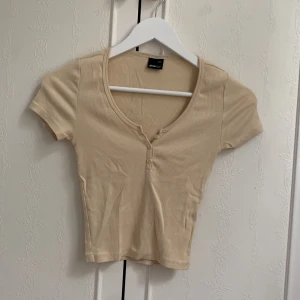 T-shirt  - En beige tröja i storlek xxs men är väldigt stretchiga så funkar xs s 